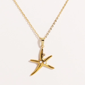 Close-up of golden starfish pendant with small pearls and rhinestone on a thin O-chain