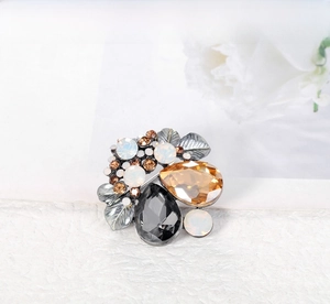 Detailed macro view of vintage crystal brooch with teardrop gemstones and silver leaves