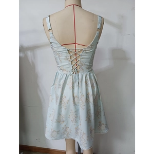 Détail du laçage croisé au dos et de l'ourlet floral sur une robe d'été bleu clair