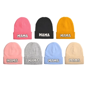 Detail of embroidered MAMA letters on colorful cuffed knit beanies for children