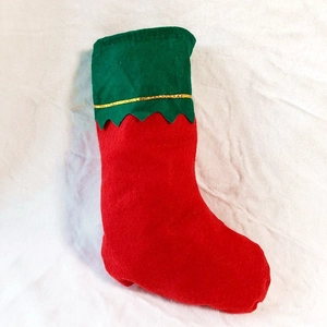 Detail showing red felt Christmas stocking with green cuff and golden wavy trim decoration