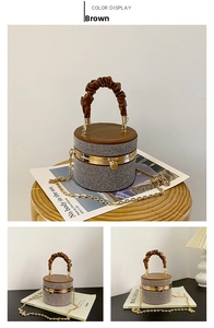 Close-up of brown leather cylinder bag with sparkling rhinestones and golden chain strap