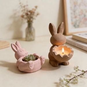 Detail of pink reclining bunny planter and brown rabbit eggshell candle holder in a cozy home setting