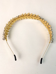 Close-up of golden metal leaf headband with crystal beads and detailed leaf textures