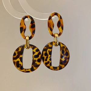 Detail view of retro leopard print acrylic earrings with gold metal connectors