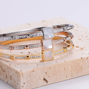 18K gold and silver square shell bangles with cubic zirconia on natural stone base