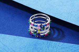 Macro shot of wide hollow silver ring with colorful rectangular zircons and tiny diamonds