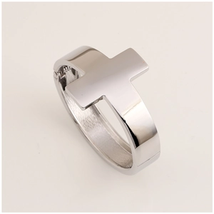 Macro shot of a silver metal cross bangle with a polished finish and hinge design