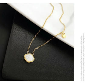 Macro detail of gold-plated seashell necklace with white mother of pearl inlay