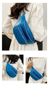 Detailed view of blue leather crossbody chest bag with silver zippers and chain strap