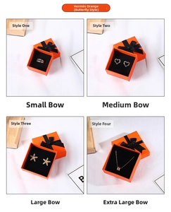 Macro detail of four orange jewelry gift boxes with black ribbon bows and inserts