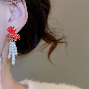 Close-up of New Chinese style red dragon stud earrings with white pearl tassels