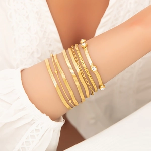 8-piece gold layered bracelet set featuring snake chains and zircon stones on wrist