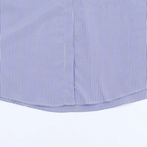 Détail macro d'une chemise à rayures verticales bleues et blanches avec ourlet courbé précis