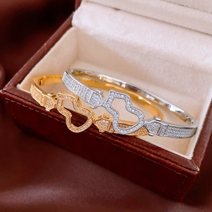 Close-up of 18K gold plated gourd bangle with pavé zircons in a luxury jewelry box