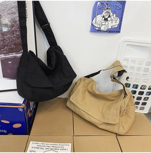 Detail showing black and khaki washed canvas messenger bags with adjustable shoulder straps
