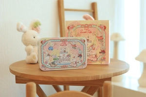 Detailed view of pink tin storage box with matching gift bag and bunny illustration