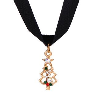 Macro shot of gold Christmas tree pendant with rhinestones on a black velvet choker