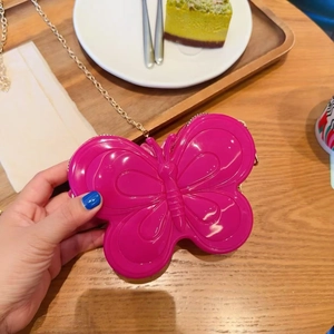 Détail du sac papillon rose fuchsia avec texture en relief 3D et chaîne dorée chic