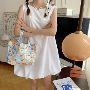 Détail d'un sac cabas en toile avec motifs floraux rétro et étiquette logo LOVE SOZAKKA