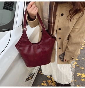 Detail van bordeauxrode tote bag met geometrische stiksels en zachte leertextuur