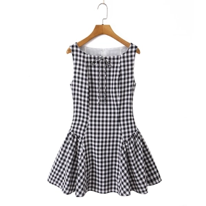 Detail of gingham sleeveless dress featuring a tied bow neckline and smocked texture