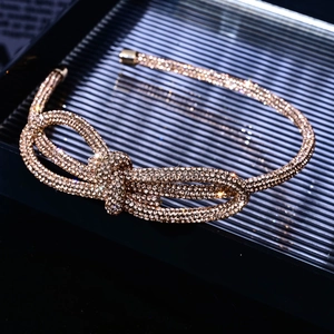 Close-up of sparkling rhinestone bow detail on a luxury golden metal headband