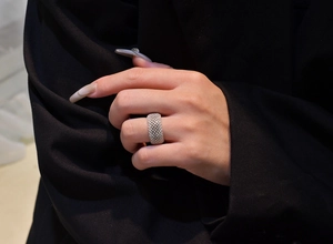 Macro shot of silver-plated mesh ring with pave-set sparkling zircons on female index finger