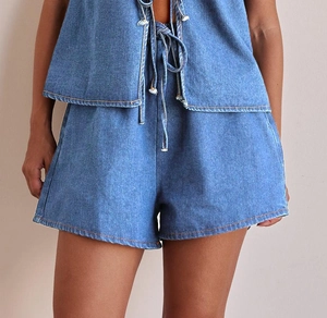 Detail of blue denim sleeveless halter top with tie-waist and high-waist shorts set