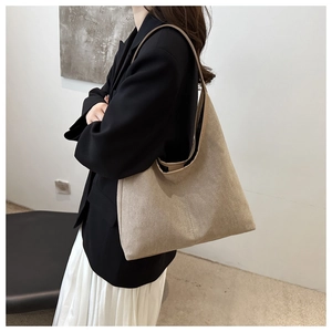 Detail view of large beige suede shoulder bag on model with soft texture and minimalist design