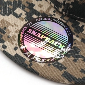 Detailed macro view of digital camouflage snapback cap with holographic laser sticker