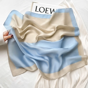 Elegant light blue and beige silk scarf showing smooth texture and soft color contrast