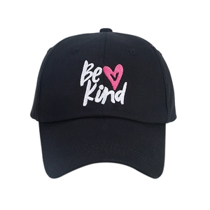 Classic black cotton baseball cap with Be Kind embroidery and pink heart on white background