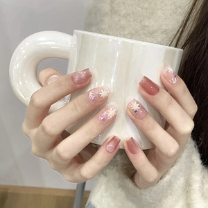 Detail of handmade press-on nails with pink cat-eye effect and 3D floral art design