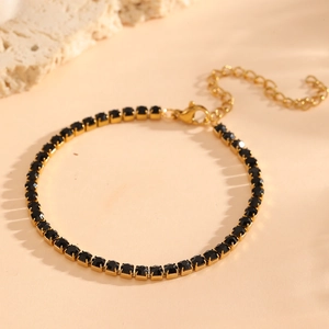 Detail of 18K gold-plated titanium tennis bracelet featuring black zircon stones