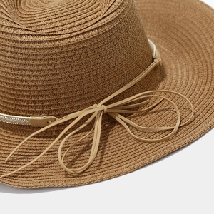 Detail shot of khaki straw sun hat with rhinestone band and leather bow accent