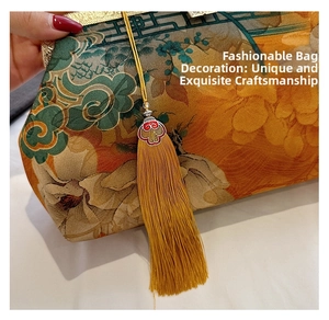 Close-up of vintage floral brocade handbag with golden clasp and yellow tassel detail