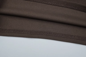 Detail von kaffeebraunem Rippstrick-Stoff mit hochwertiger Naht und Materialstruktur