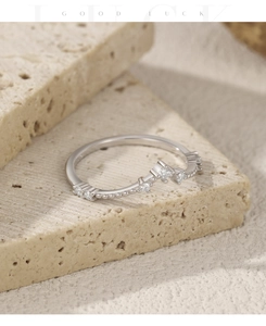 Detailed view of silver V-shaped moissanite crown ring with fine bead edge and brilliant stones