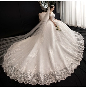 Detailed view of luxury off-the-shoulder wedding dress with long sequin lace train