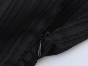 Détail de la fermeture éclair invisible en goutte d'eau sur robe noire texturée