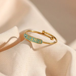 Macro detail of adjustable gold mama ring with turquoise enamel and small rhinestone