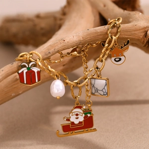 Detail of 18K gold-plated Christmas bracelet with Santa and reindeer charms on wood
