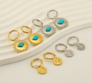 Macro detail of eight bohemian sunflower earrings with turquoise stone in gold and silver