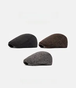 Flat lay of vintage wool newsboy caps in charcoal, coffee, and grey herringbone tweed
