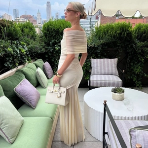 Detail of elegant off-shoulder ruched mesh dress with side slit in cream white