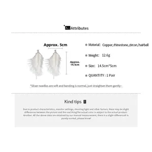 Detail view of long white feather tassel earrings with sparkling rhinestones and silver needles