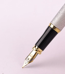 Macro shot of silver textured fountain pen with iridium point nib and metallic details
