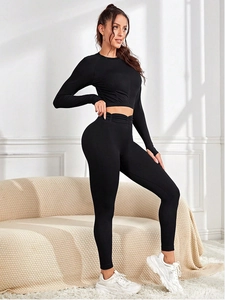 Détail d'un ensemble de yoga noir avec poignets passe-pouce et texture en maille côtelée