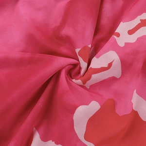 Vue détaillée du tissu en maille rose à fleurs avec volants et motifs imprimés vibrants